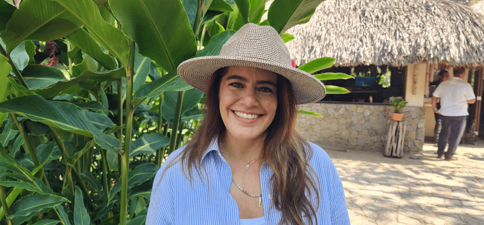 Karina Adame, directora de operaciones del Jardín Botánico de Acapulco, sonriendo frente a vegetación tropical.